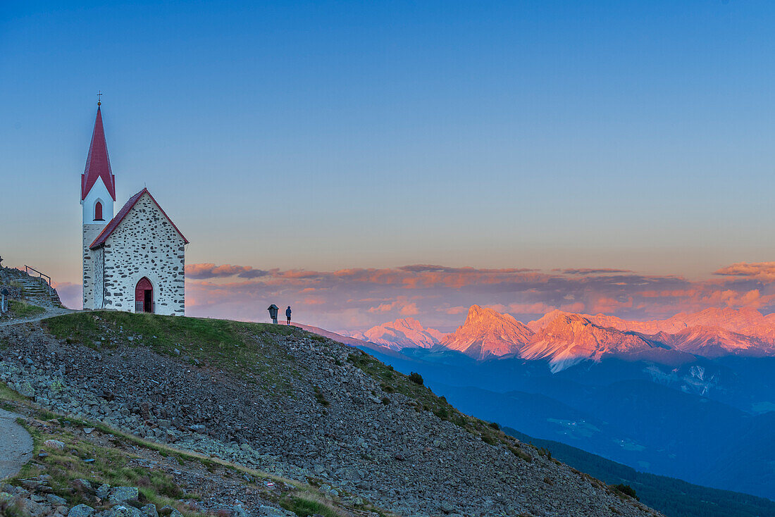 Man enjoys sunset over Dolomites at the pilgrimage church of Lazfons, Chiusa, Bolzano district, South Tyrol, Italy, Europe