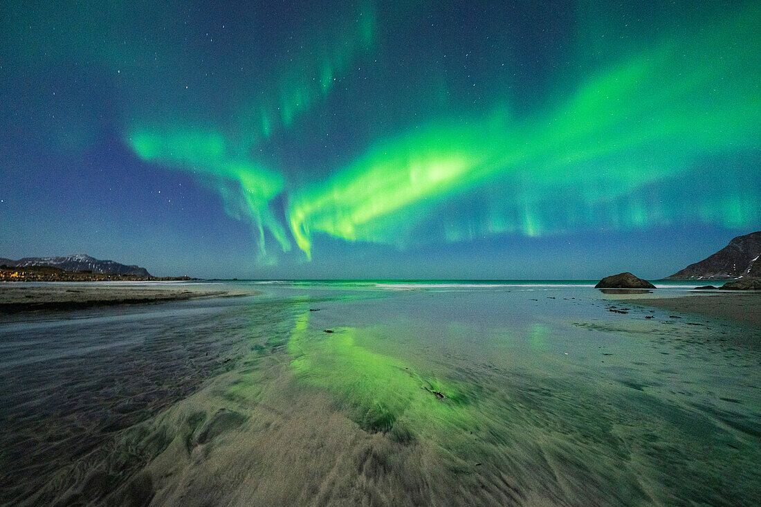 Sternenklarer Nachthimmel mit Nordlicht (Aurora Borealis), das sich im kalten Meer spiegelt, Skagsanden Strand, Ramberg, Nordland, Lofoten Inseln, Norwegen, Skandinavien, Europa