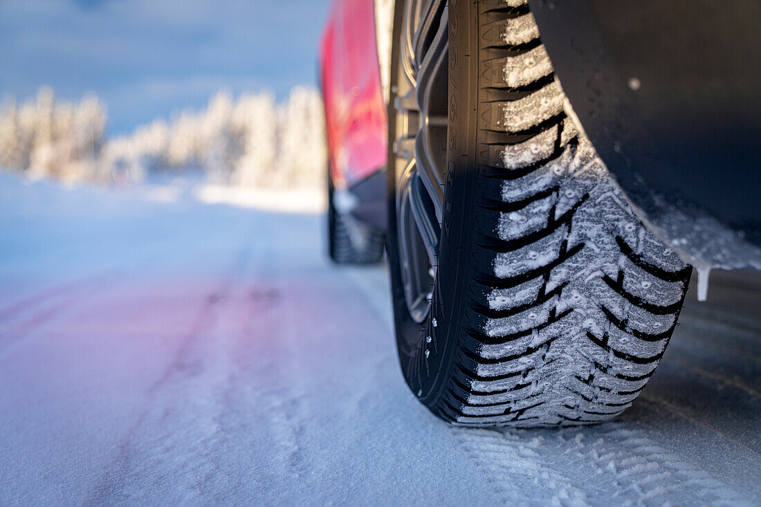 Winterreifen eines Autos, das auf einer glatten Straße im verschneiten Wald fährt, Kangos, Norrbotten County, Lappland, Schweden, Skandinavien, Europa