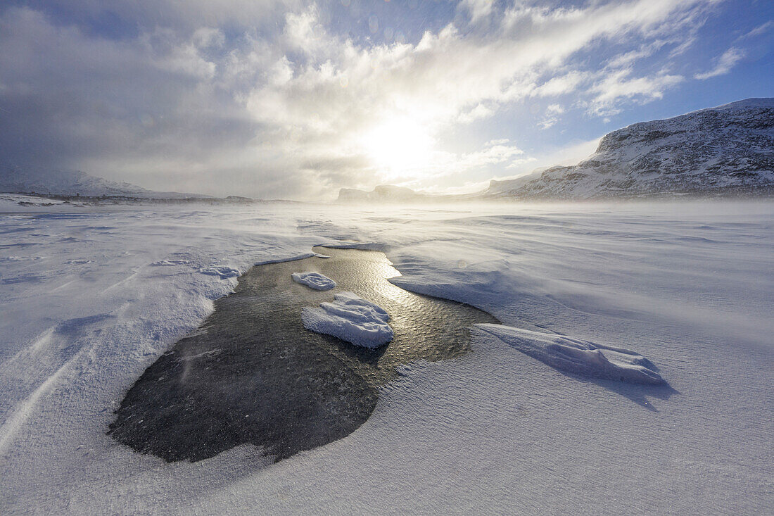 Wolken bei Sonnenuntergang über einem zugefrorenen, schneebedeckten See nach einem Schneesturm, Stora Sjofallet, Landkreis Norrbotten, Lappland, Schweden, Skandinavien, Europa
