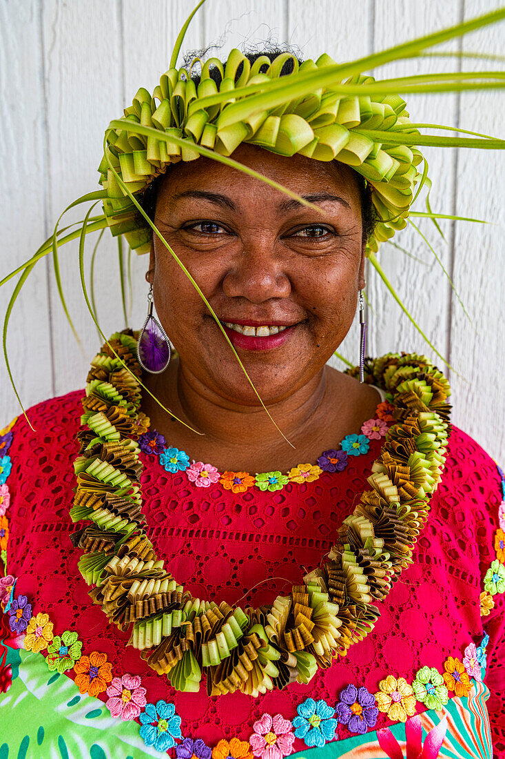 Bunt gekleidete Frau mit gewebtem Blätterband auf dem Kopf, Hikueru, Tuamotu-Archipel, Französisch-Polynesien, Südpazifik, Pazifik