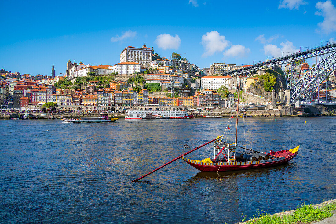 Blick auf die Brücke Dom Luis I über den Fluss Douro und das Rabelo-Boot, ausgerichtet auf bunte Gebäude, UNESCO-Weltkulturerbe, Porto, Norte, Portugal, Europa