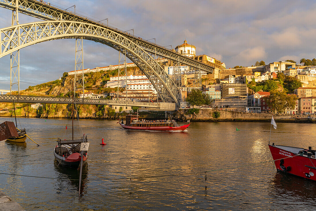 Blick auf Boote, die Brücke Dom Luis I., UNESCO-Weltkulturerbe, und den Fluss Douro bei Sonnenuntergang, Porto, Norte, Portugal, Europa