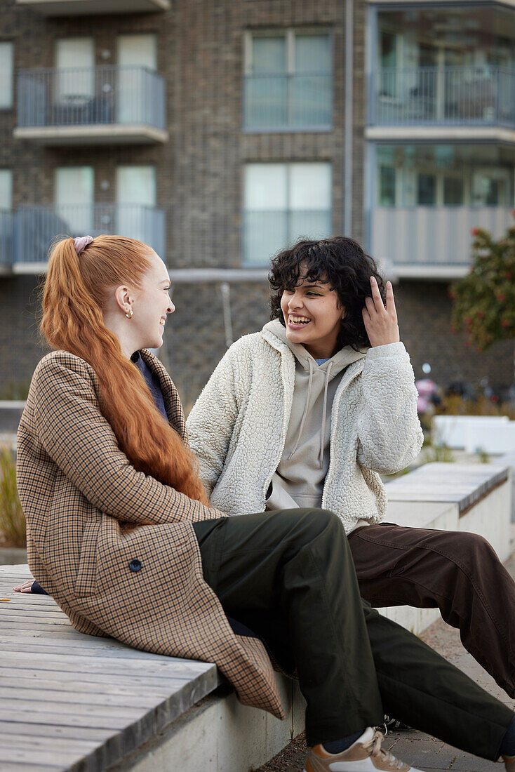 Young female friends sitting outdoors