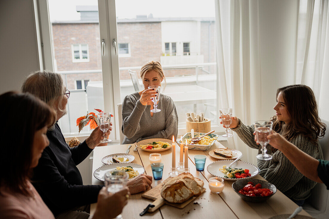 Familie stößt beim Abendessen an