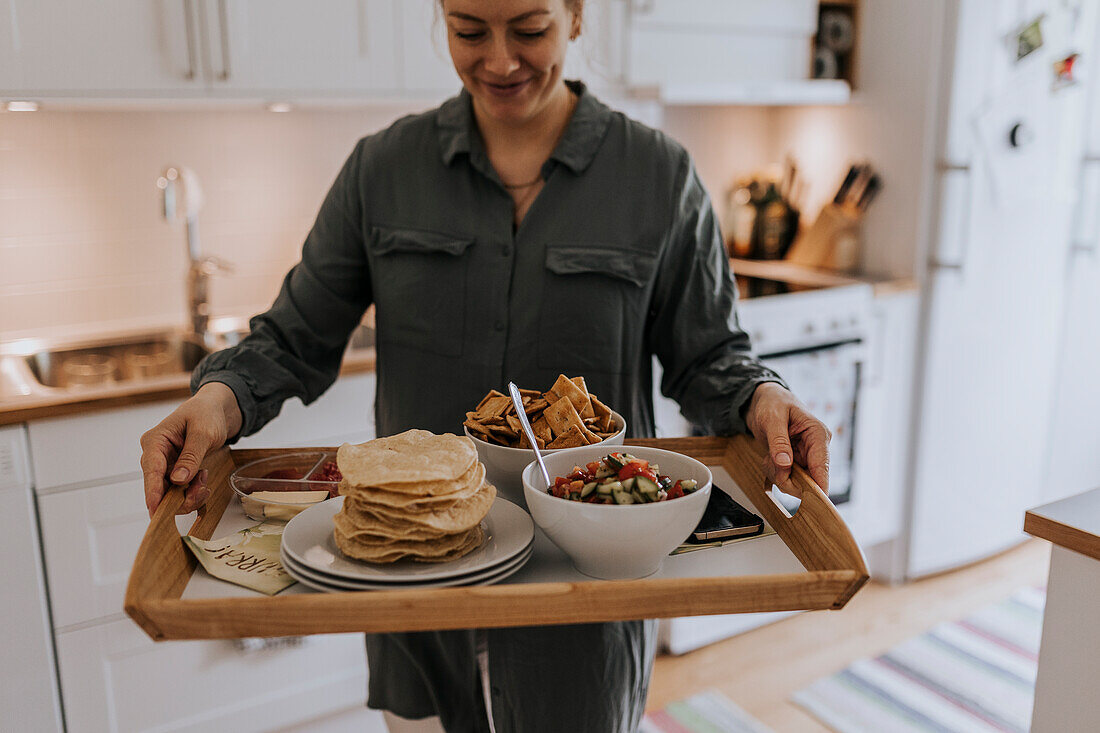 Frau trägt Tablett mit Essen