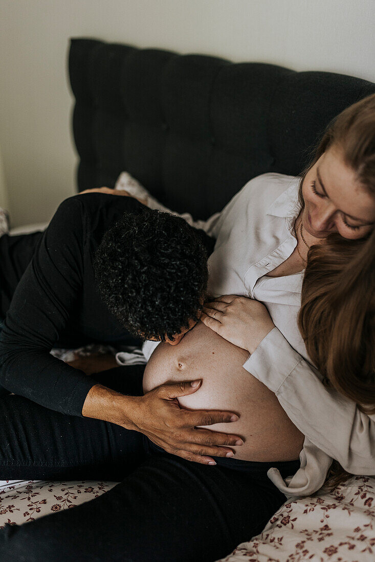 Man kissing pregnant girlfriend's belly