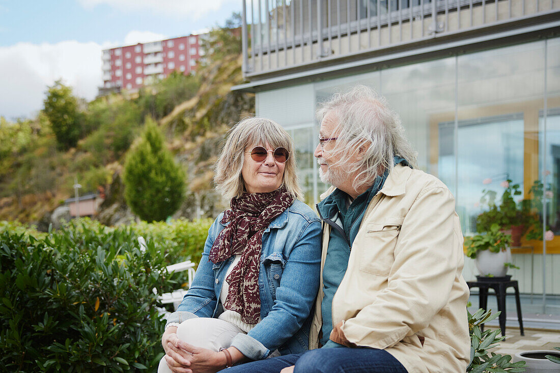 Smiling senior couple sitting outdoors