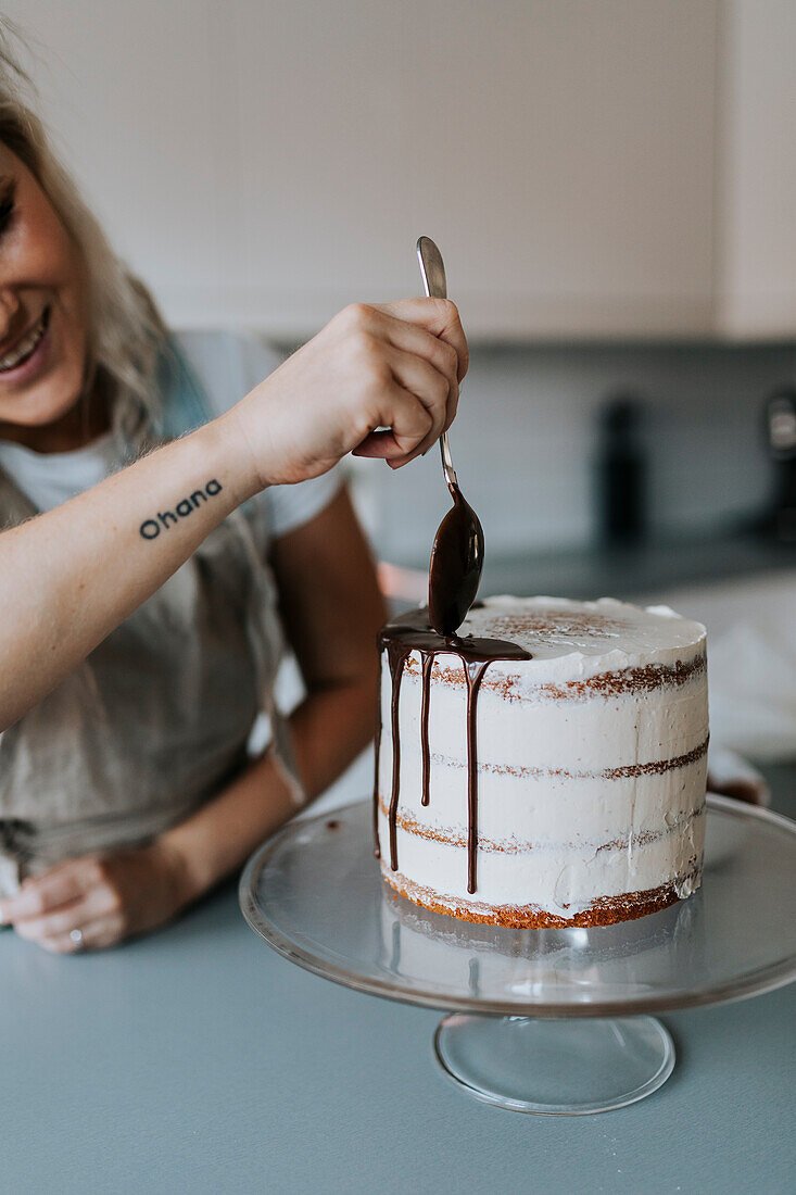 Woman in kitchen decorating cake