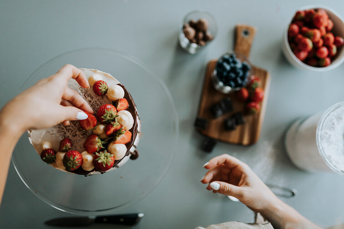 Frau in der Küche beim Verzieren von Kuchen