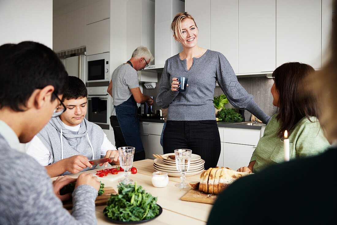 Family sitting at table and preparing meal