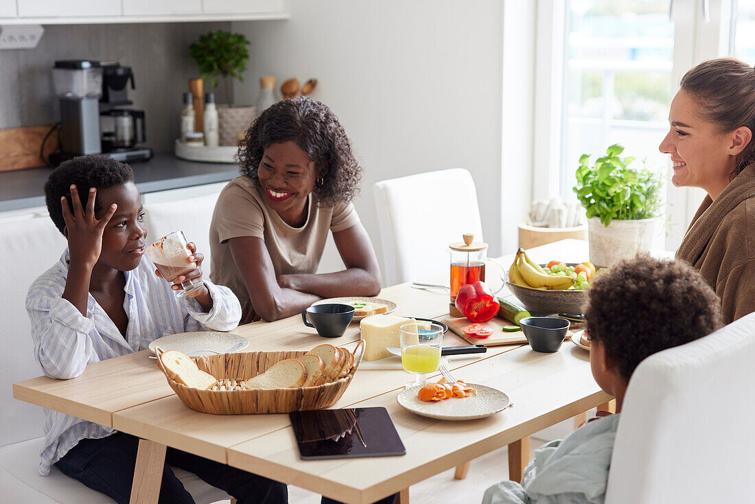 Family sitting at table and eating breakfast