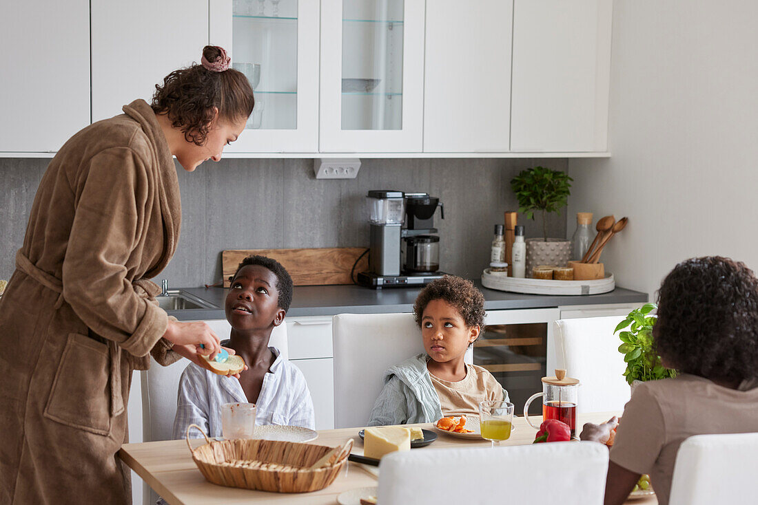 Family sitting at table and eating breakfast