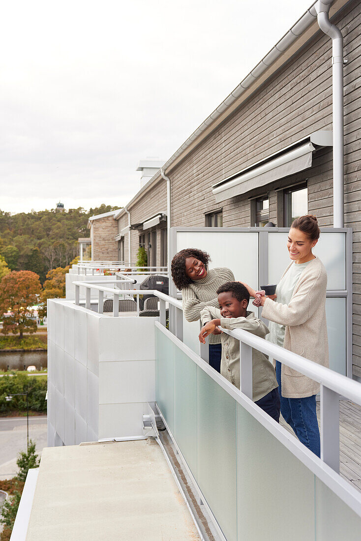 Mothers and son standing on balcony