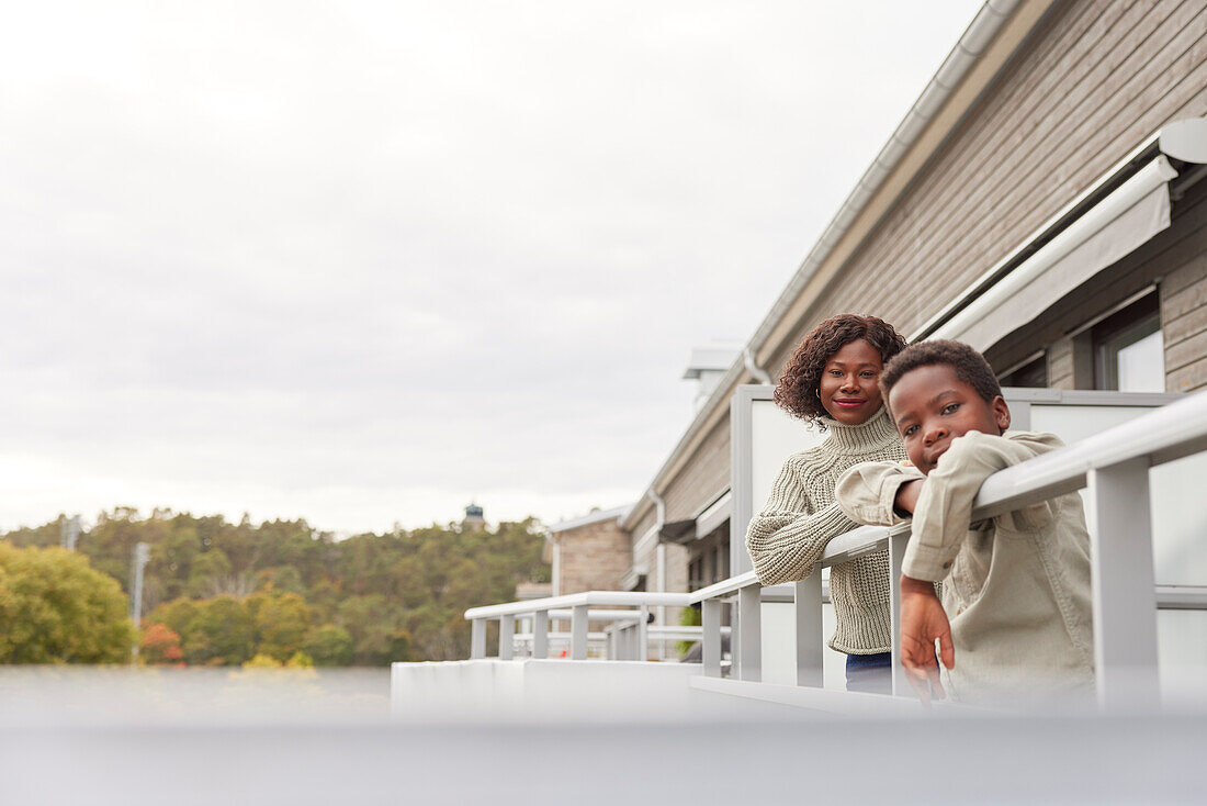 Portrait of mother and son standing on balcony