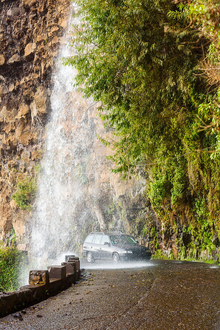 Car on road under waterfall