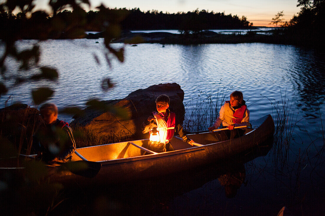 Children sitting in kayak at dusk