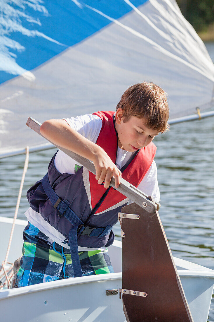 Boy holding rudder on boat