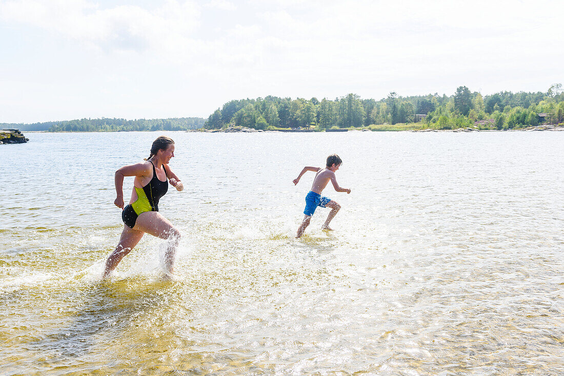 Mother running with son in lake