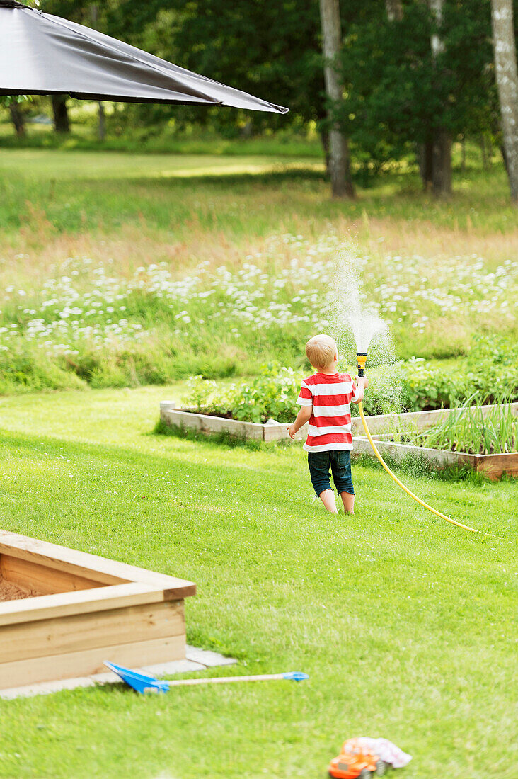 Boy playing with garden hose