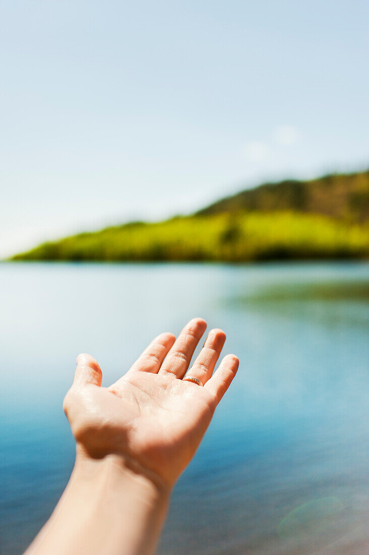 Menschliche Hand am See