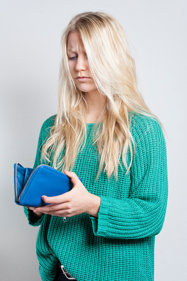 Young woman looking at wallet