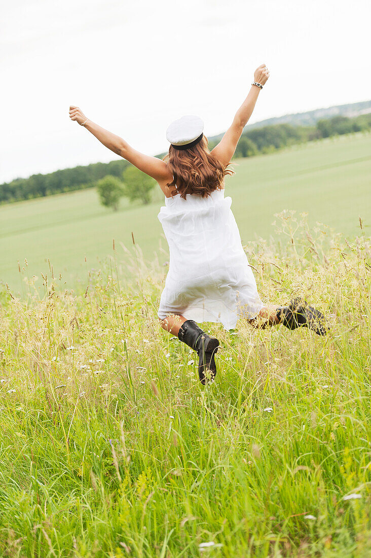 Young woman jumping in field