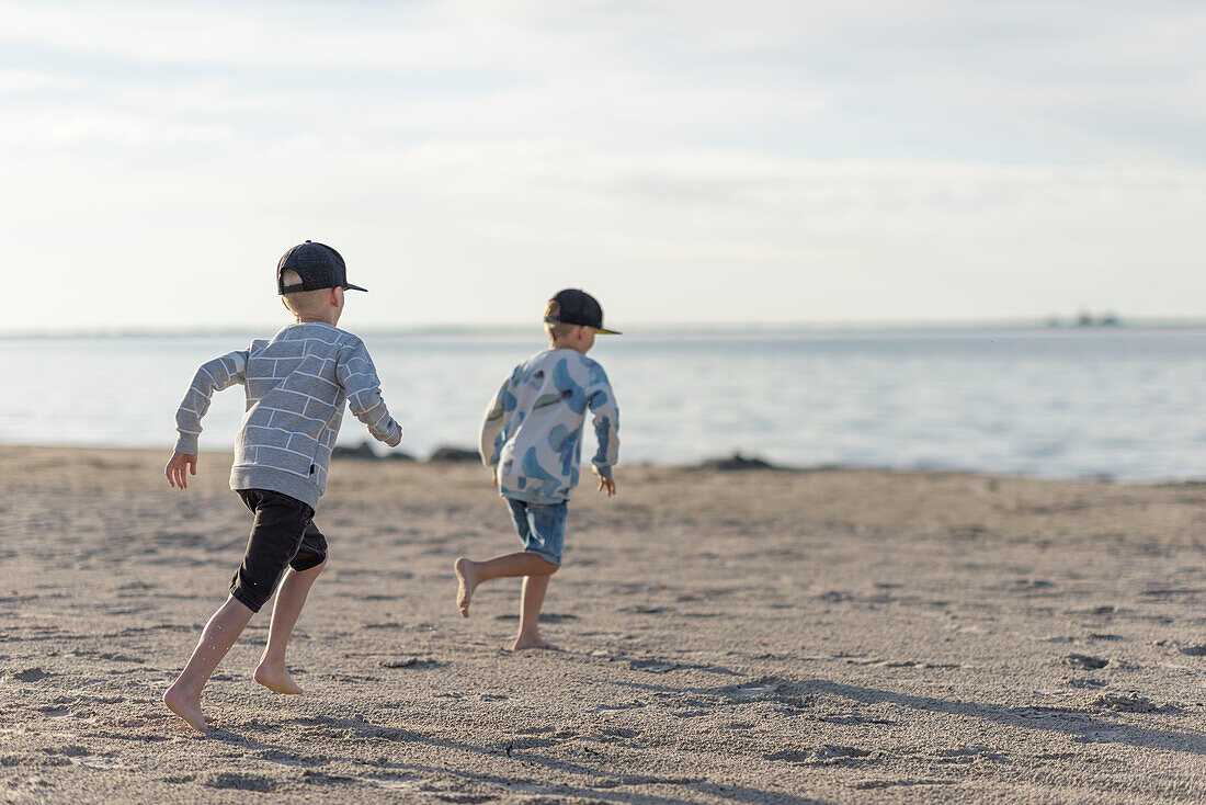 Jungen rennen am Strand