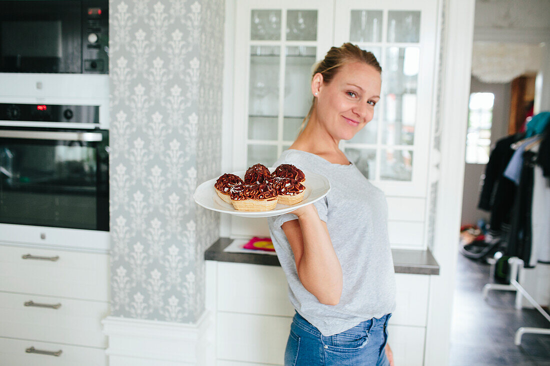 Smiling woman holding snacks on plate