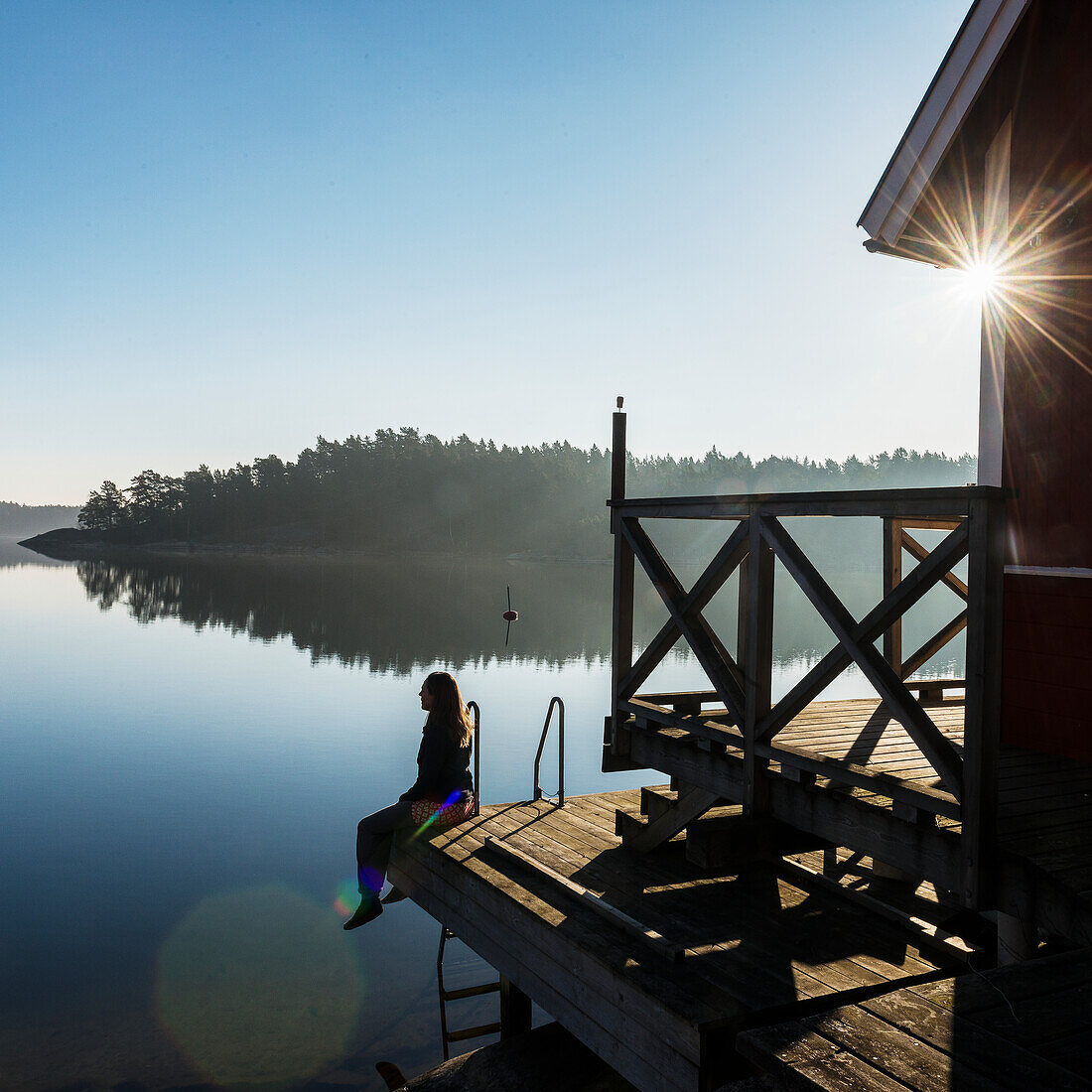 Frau sitzt am See