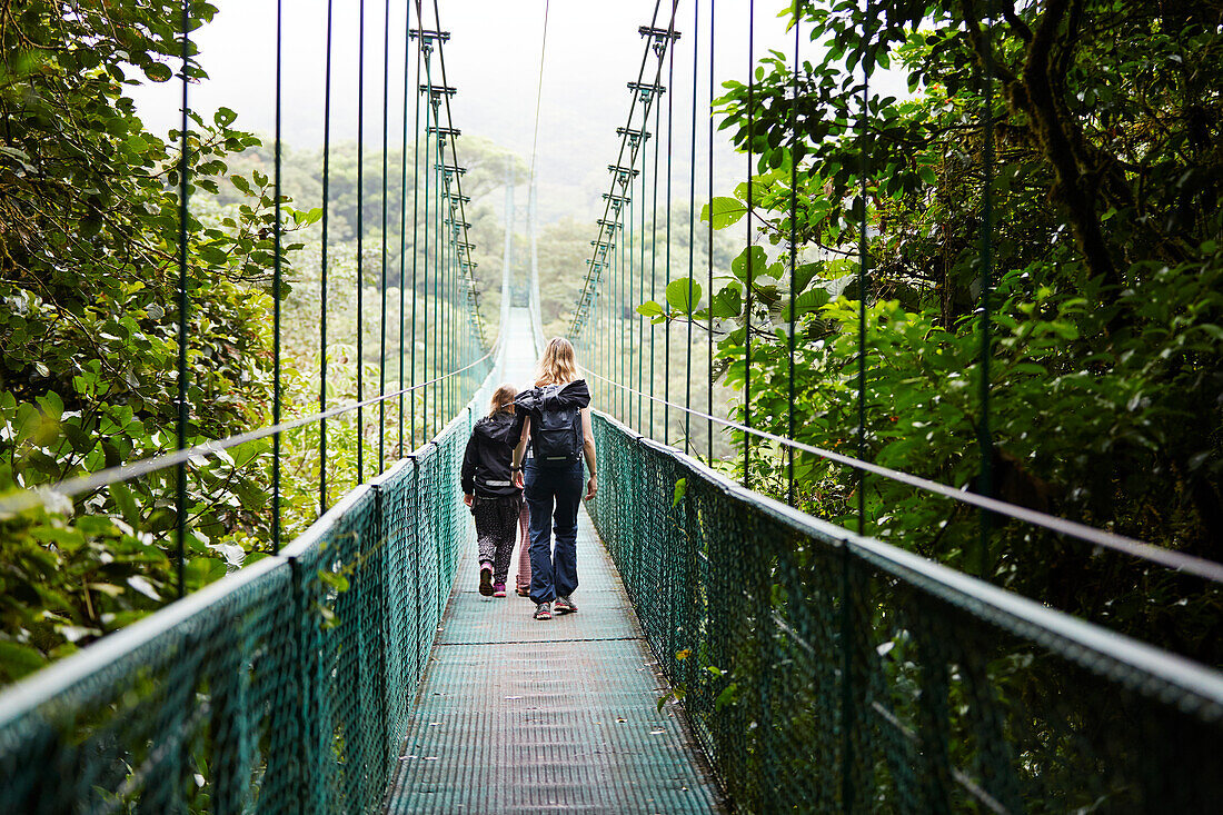 Mother with daughters on hanging bridge