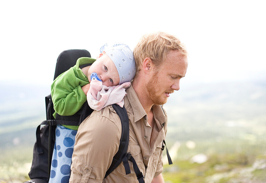 Vater wandert mit Tochter im Tragesitz