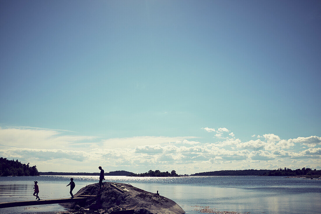 Silhouetten von Menschen am Meer