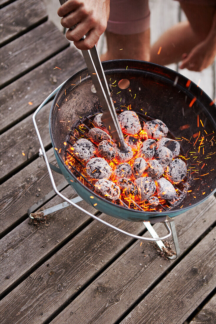 Preparing charcoal in grill