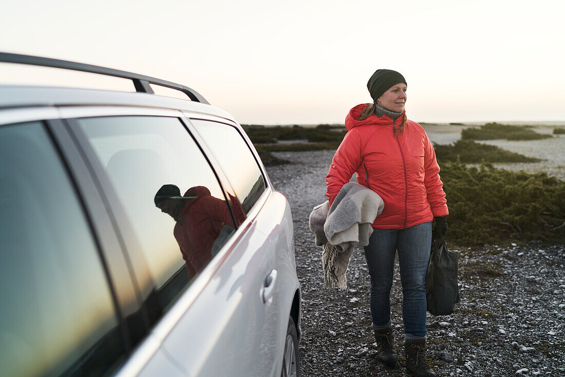 Woman at sea near car