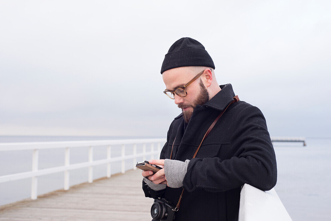 Man on pier with smartphone