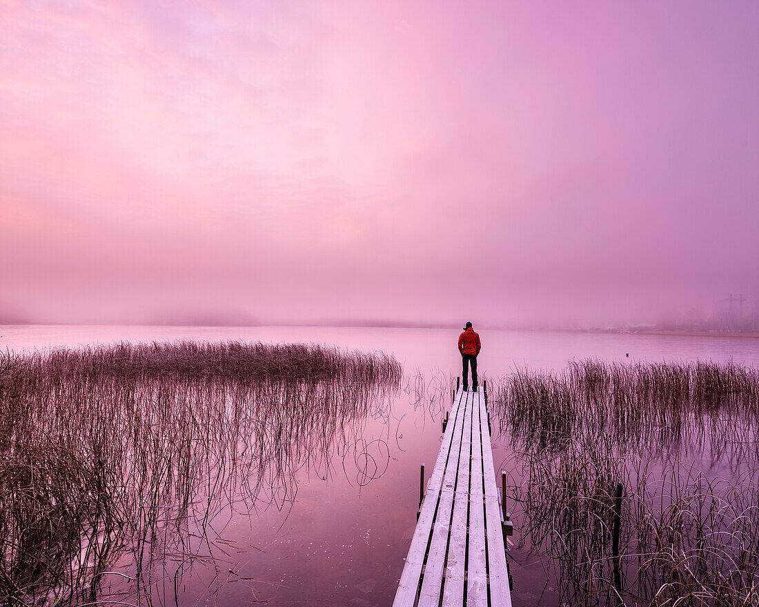 Man on jetty at sunrise