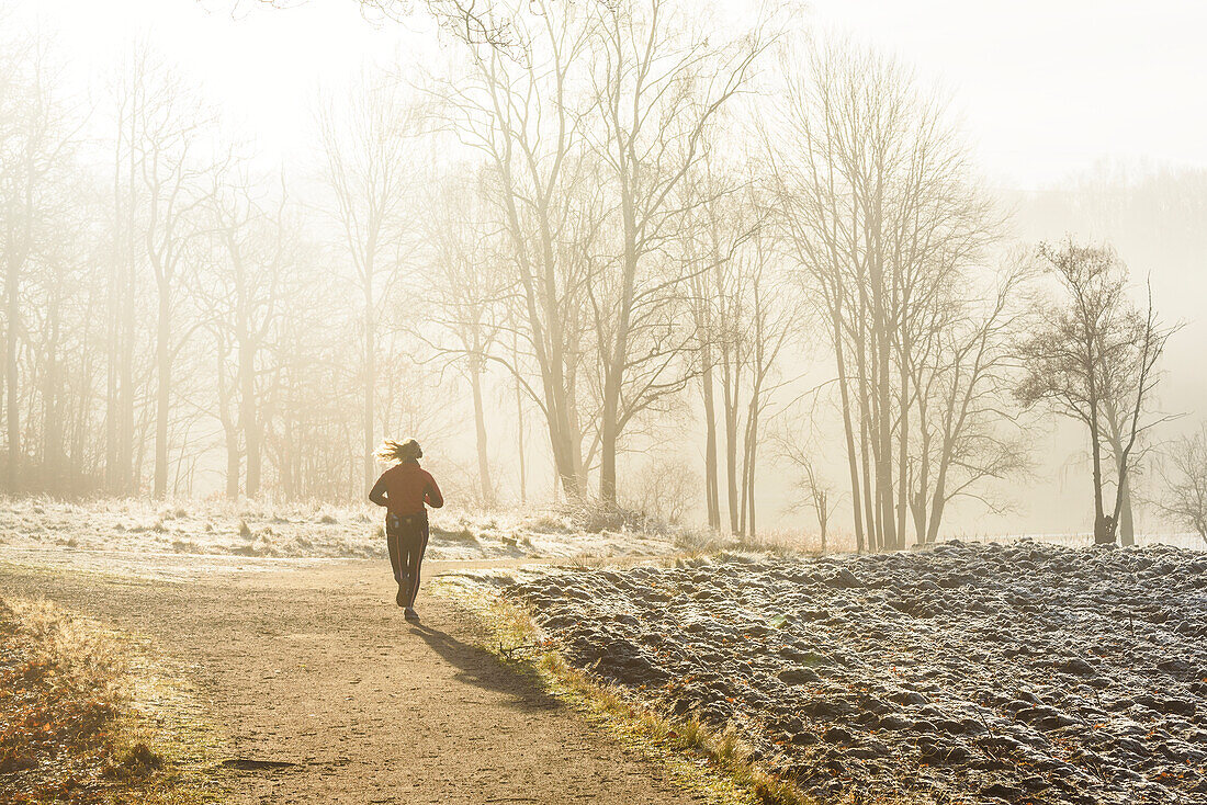 Woman jogging at foggy morning