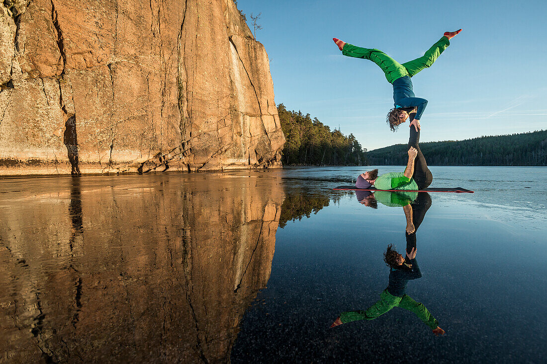 Paar macht Yoga auf zugefrorenem See