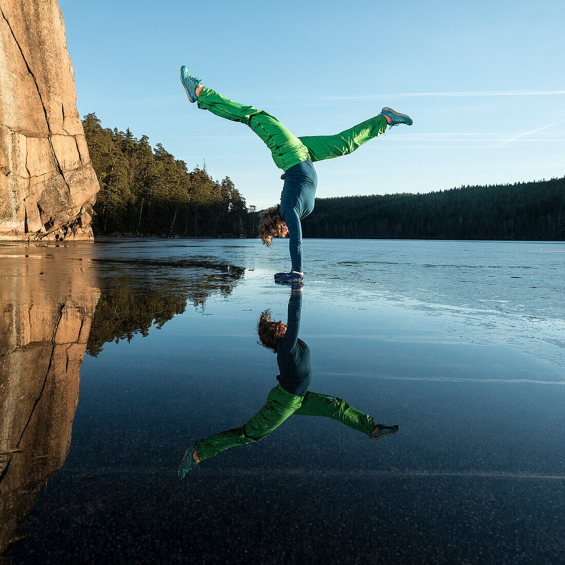 Frau macht Yoga auf einem zugefrorenen See