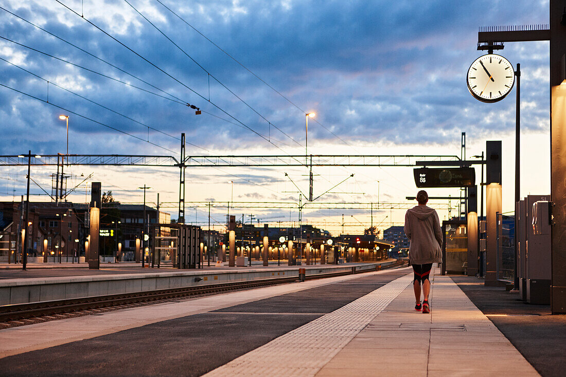 Woman in workout clothes walking away at train station