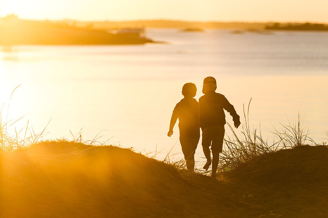 Kinder spazieren bei Sonnenuntergang