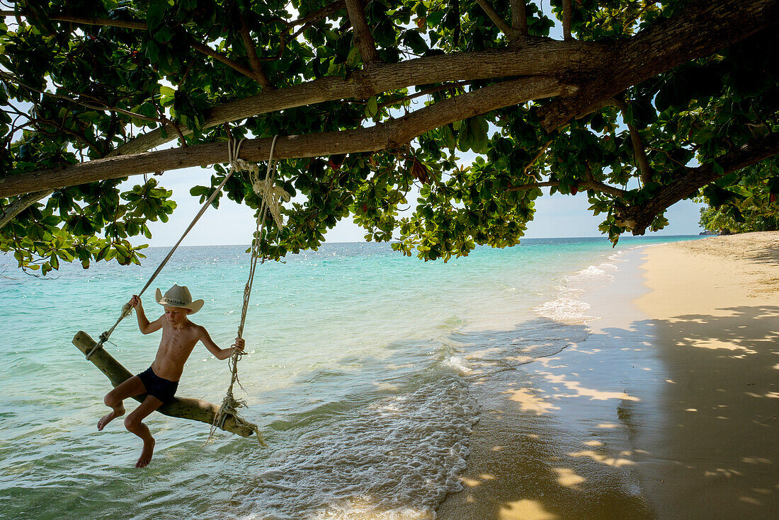 Boy swinging on beach