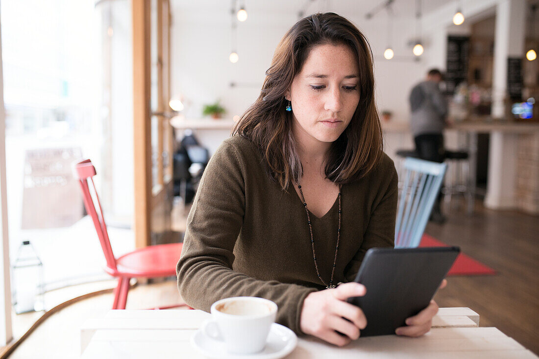 Frau mit digitalem Tablet in einem Café