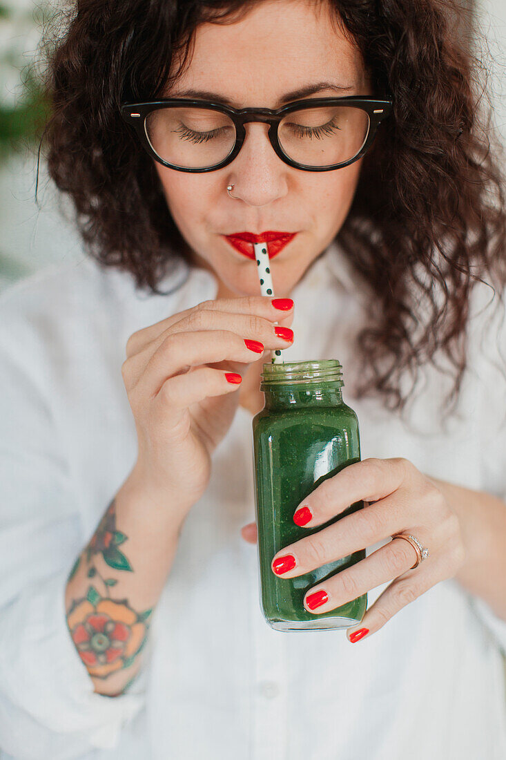 Junge Frau trinkt Smoothie