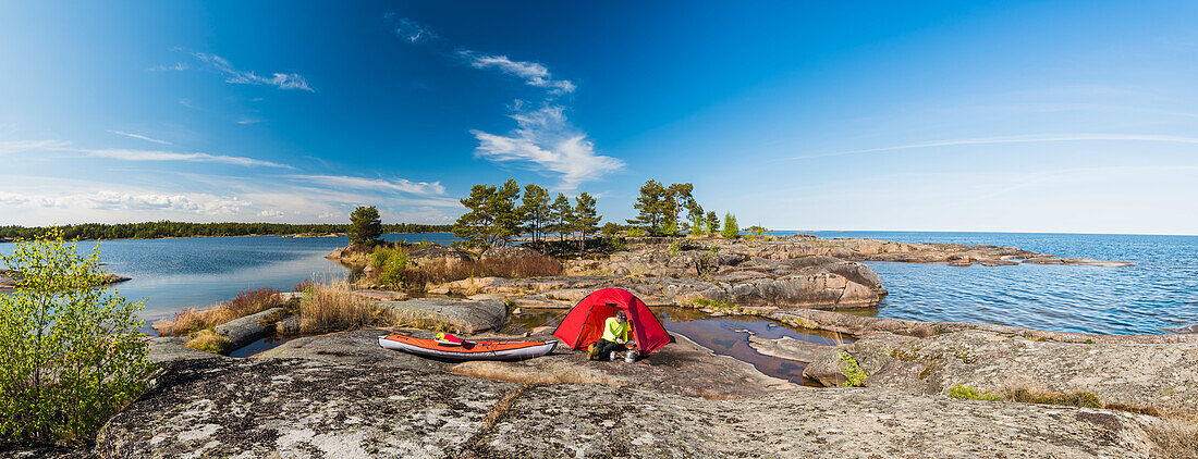 Man by tent at coast