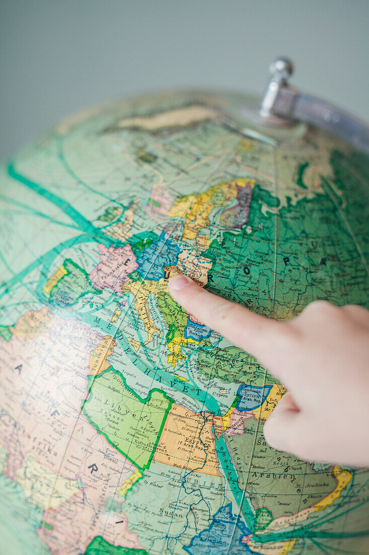 Boy pointing at globe