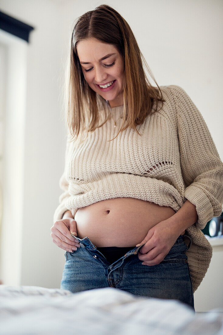 Pregnant woman getting dressed