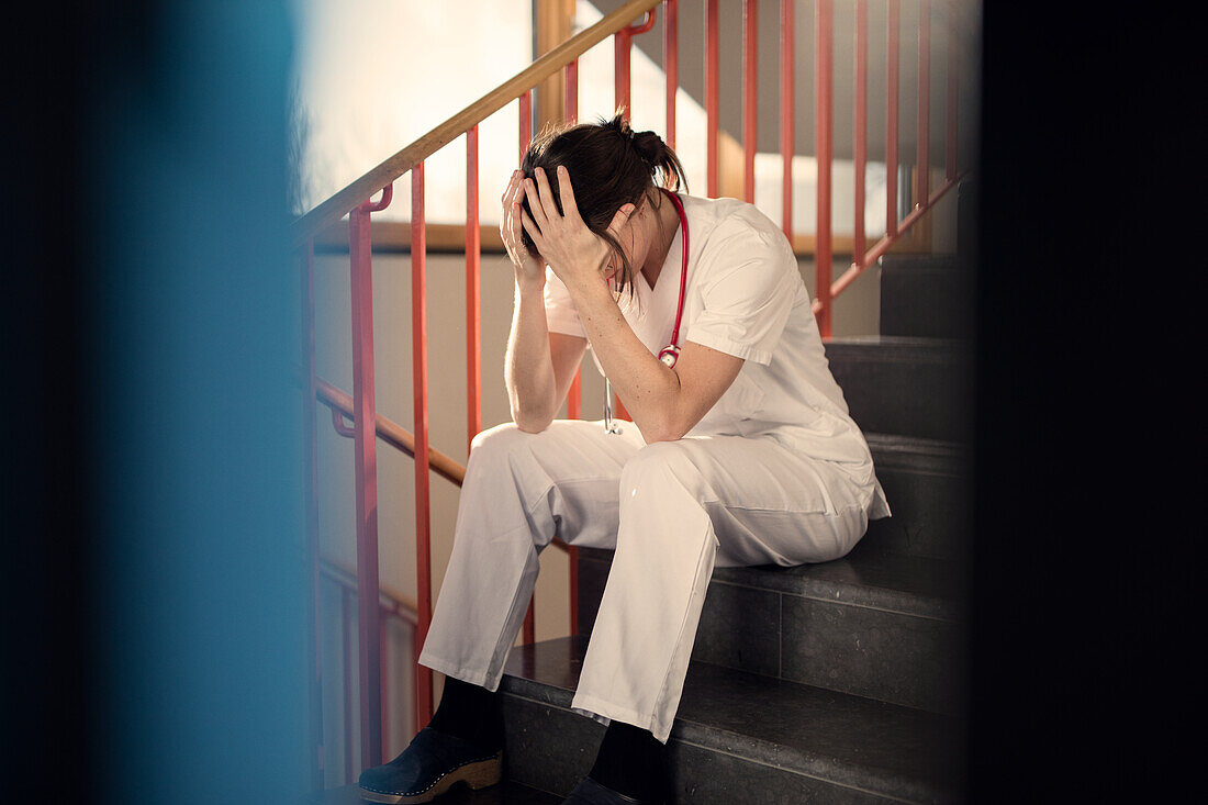 Female doctor sitting on stairs