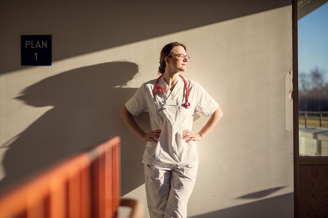Female doctor standing by wall
